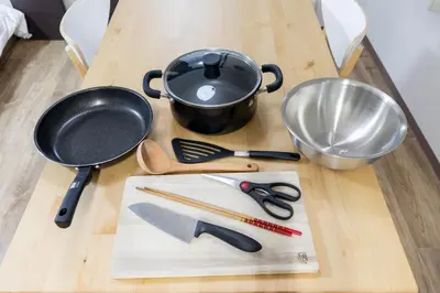a wooden table with utensils and a frying pan and a skillet at \u6d45\u8349\u30a2\u30d1\u30fc\u30c8\u30e1\u30f3\u30c8301 in Tokyo