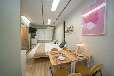 a room with a bed and a table and chairs at \u677e\u304c\u8c37\u30a2\u30d1\u30fc\u30c8\u30e1\u30f3\u30c8201 in Tokyo