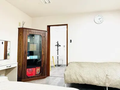 a bedroom with a bed and a clock on the wall at KOBAYASHi \u6771\u4eac in Tokyo