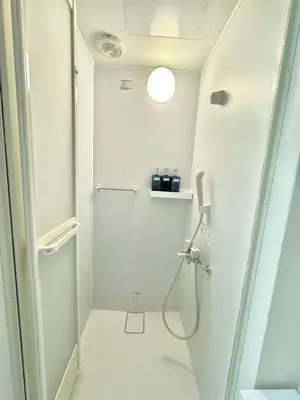a white bathroom with a shower and a toilet at KOBAYASHi \u6771\u4eac in Tokyo