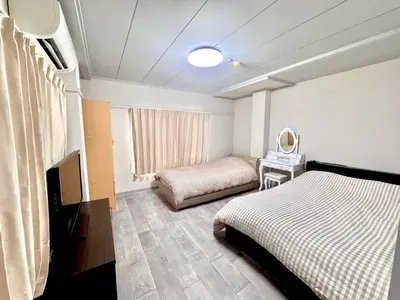a bedroom with two beds and a television in it at KOBAYASHi \u6771\u4eac in Tokyo