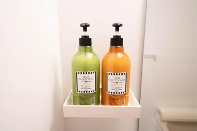 three bottles of wine sitting on a shelf in a refrigerator at \u677e\u304c\u8c37\u30a2\u30d1\u30fc\u30c8\u30e1\u30f3\u30c8101 in Tokyo