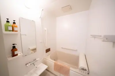 a white bathroom with a tub and a sink at \u677e\u304c\u8c37\u30a2\u30d1\u30fc\u30c8\u30e1\u30f3\u30c8101 in Tokyo