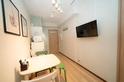 a small room with a table and a tv on a wall at \u677e\u304c\u8c37\u30a2\u30d1\u30fc\u30c8\u30e1\u30f3\u30c8101 in Tokyo