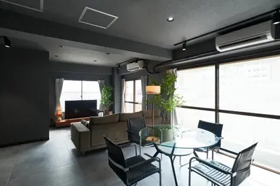 a living room with a glass table and chairs at ACOE M O R I S H I T A - Direct Access to Tokyo Attractions in Tokyo