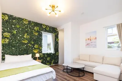 a bedroom with a green wall with a bed and a couch at Prim Square, 8min walk to Shibuya Sta in Tokyo