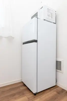 a white refrigerator in a room with a wall at Prim Square, 8min walk to Shibuya Sta in Tokyo