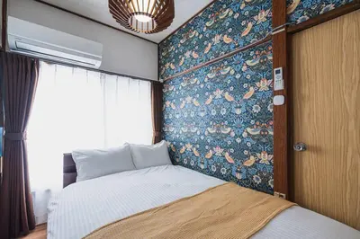 a bedroom with a bed with a floral wall at House YOYOGI Park, Shibuya Area, 4 Minutes to Yoyogi Park, 4-Bedroom, Sleeps 8 in Tokyo