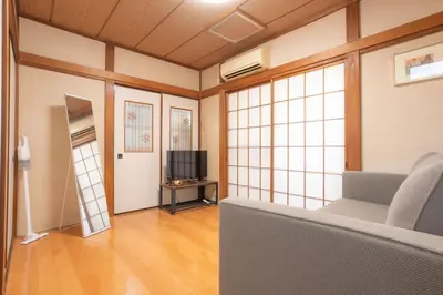 a living room with a couch and a tv at Kamitagata House in Nakano Sleeps 7Just Steps from Araiyakushi-Mae Station in Tokyo