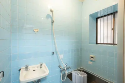 a blue tiled bathroom with a sink and a shower at Kamitagata House in Nakano Sleeps 7Just Steps from Araiyakushi-Mae Station in Tokyo