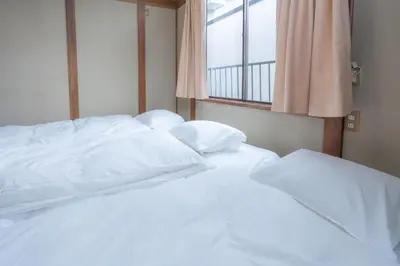 a white bed in a room with a window at Kamitagata House in Nakano Sleeps 7Just Steps from Araiyakushi-Mae Station in Tokyo
