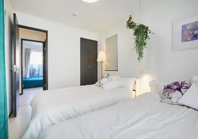 two beds in a room with white walls at Naka HOUSE in Tokyo