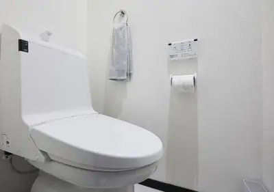 a white bathroom with a toilet and a towel at Naka HOUSE in Tokyo
