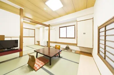 a living room with a table and chairs at Business Hotel Yamashiro in Tokyo