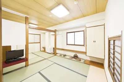 a living room with a flat screen tv and a window at Business Hotel Yamashiro in Tokyo