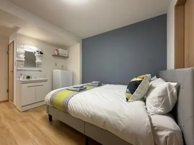 a bedroom with a bed with a blue wall at nestay apartment tokyo kagurazaka in Tokyo