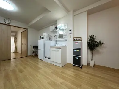 an empty room with a kitchen with white appliances at nestay apartment tokyo kagurazaka in Tokyo