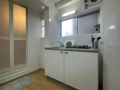 a white kitchen with a sink and a window at nestay apartment tokyo kagurazaka in Tokyo