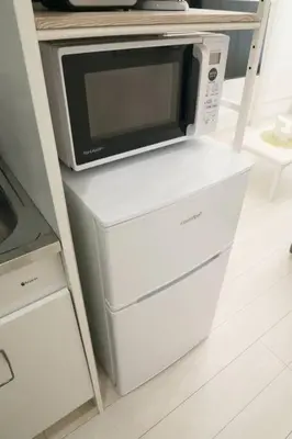 a microwave oven sitting on top of two refrigerators at \u30bb\u30f3\u30c8\u30ec\u30a4\u62bc\u4e0a\u30ce\u30fc\u30b9 101 in Tokyo