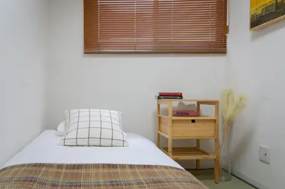 a bedroom with a bed and a nightstand and a window at Sumida River Temple Villa in Tokyo