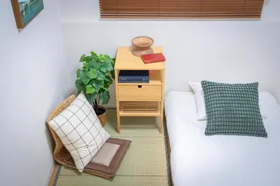 a small bedroom with a bed and a night stand at Sumida River Temple Villa in Tokyo