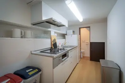 a small kitchen with a stove and a refrigerator at Sumida River Temple Villa in Tokyo