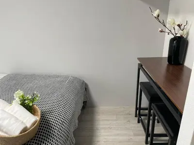a bedroom with a bed and a desk and a table with a vase at COMMA HOUSE Otsuka 3-1 in Tokyo