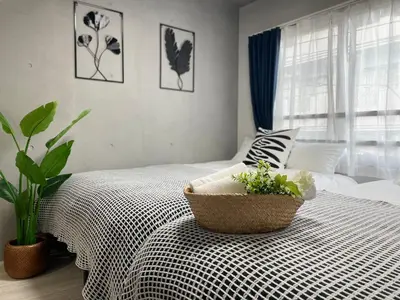 a bedroom with a bed with a basket on it at COMMA HOUSE Otsuka 3-1 in Tokyo