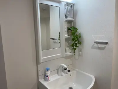 a bathroom with a sink and a mirror at COMMA HOUSE Otsuka 3-2 in Tokyo
