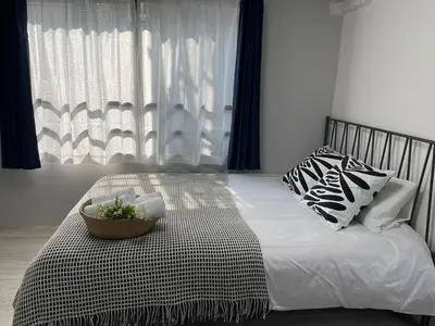 a bedroom with a bed with a bowl of flowers on it at COMMA HOUSE Otsuka 3-2 in Tokyo
