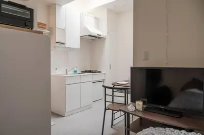 a living room with a tv and a kitchen at new!\u9580\u524d\u4ef2\u753a \u8d8a\u4e2d\u5cf6\u304b\u3089\u5f92\u6b695\u5206! \u9280\u5ea7 \u6d45\u8349 \u30b9\u30ab\u30a4\u30c4\u30ea\u30fc \u7bc9\u5730 \u8c4a\u6d32 \u821e\u6d5c\u3078\u30a2\u30af\u30bb\u30b9\u826f\u597d in Tokyo