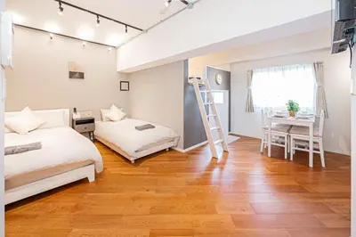 a bedroom with two beds and a desk and a ladder at \u65b0\u5bbf\u5340\u6771\u65b0\u5bbf\u7ad9\u5f92\u6b652\u5206\u9418\u623f\u6e90\u4ea4\u901a\u65b9\u4fbf\u514d\u8cbbWi-Fi in Tokyo