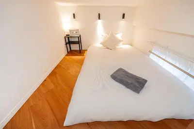 a bedroom with a white bed with a pillow on it at \u65b0\u5bbf\u5340\u6771\u65b0\u5bbf\u7ad9\u5f92\u6b652\u5206\u9418\u623f\u6e90\u4ea4\u901a\u65b9\u4fbf\u514d\u8cbbWi-Fi in Tokyo