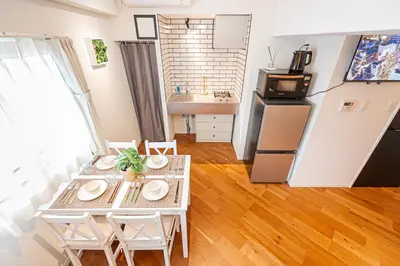 a living room with a table and a kitchen at \u65b0\u5bbf\u5340\u6771\u65b0\u5bbf\u7ad9\u5f92\u6b652\u5206\u9418\u623f\u6e90\u4ea4\u901a\u65b9\u4fbf\u514d\u8cbbWi-Fi in Tokyo