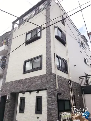 a tall brick building with windows on the side of it at Dain Hostel1 in Tokyo