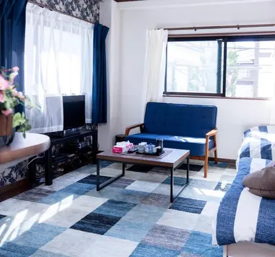 a living room with a blue couch and a coffee table at Dain Hostel1 in Tokyo