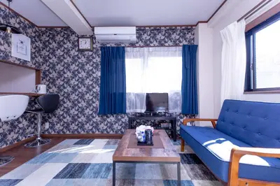 a living room with a blue couch and a table at Dain Hostel1 in Tokyo