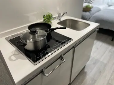 a pot sitting on top of a stove next to a sink at COMMA HOUSE Otsuka 3-3 in Tokyo