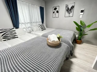 a hotel room with two beds and a couch at COMMA HOUSE Otsuka 3-3 in Tokyo