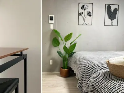 a bedroom with a plant sitting next to a bed at COMMA HOUSE Otsuka 4-1 in Tokyo