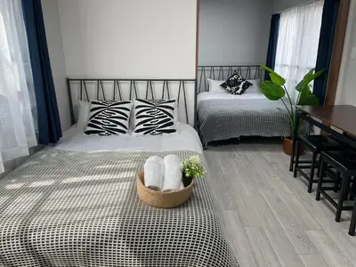 a bedroom with two beds with towels in a basket at COMMA HOUSE Otsuka 4-2 in Tokyo
