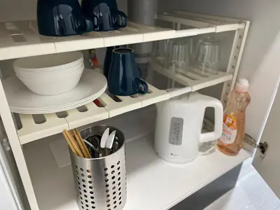 a shelf with dishes and utensils in a kitchen at COMMA HOUSE Otsuka 4-3 in Tokyo