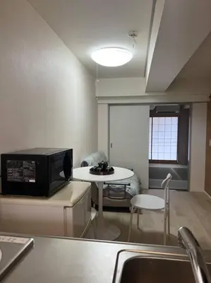 a small kitchen with a table and a microwave at shinjyuku area 602 in Tokyo