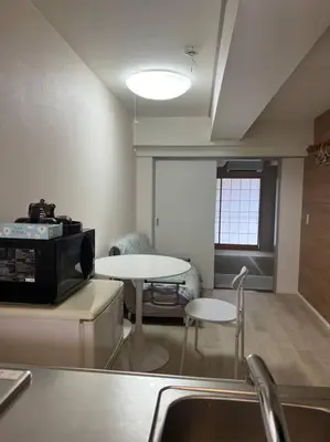 a room with a kitchen with a table and a microwave at shinjyuku area 602 in Tokyo