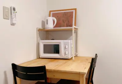 a microwave sitting on top of a wooden table at Home Story in Tokyo Kanamachi&東京屋語 in Tokyo