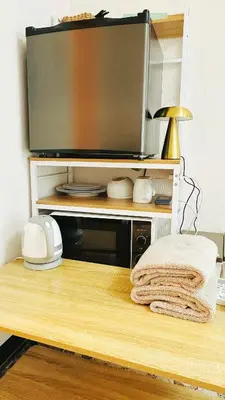 a flat screen tv on a wooden stand with a towel at Home Story in Tokyo Kanamachi&東京屋語 in Tokyo