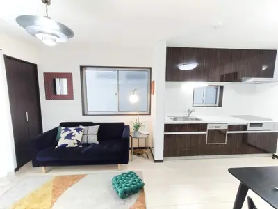 a living room with a couch and a kitchen at \u6c60\u888b\u72ec\u7acb3\u5c42\u522b\u5885 5\u5ba41\u53851\u6d74\u5ba42\u536b\u751f\u95f4 \u6700\u592712\u4eba \u94f6\u5ea7\u65b0\u5bbf\u6d89\u8c37\u4e0a\u91ce\u4e1c\u4eac\u76f4\u901a in Tokyo