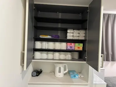 a cupboard filled with white cups and a coffee maker at Ikebukuro Area R1 NishiikeApartment 5F No Elevator in Tokyo