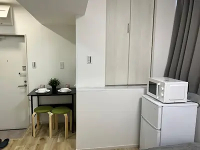 a kitchen with a small table and a microwave on a refrigerator at Ikebukuro Area R1 NishiikeApartment 5F No Elevator in Tokyo