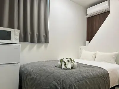 a hotel room with a bed and a tv at Ikebukuro Area R1 NishiikeApartment 5F No Elevator in Tokyo